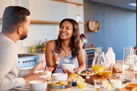 Couple smiling while enjoying meal at home