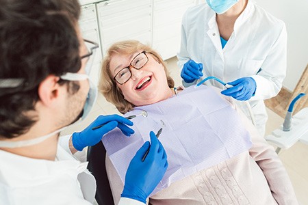 Dentist talking to smiling patient during checkup