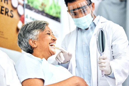 dentist showing patient smile in reflection