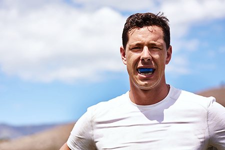 Man wears athletic mouthguard