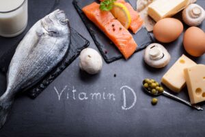 Fish, cheese, eggs, and mushrooms on a chalk board where "vitamin D" is written